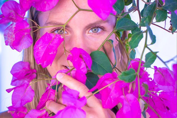 Portrait of a woman framed by bougainvillea blossoms